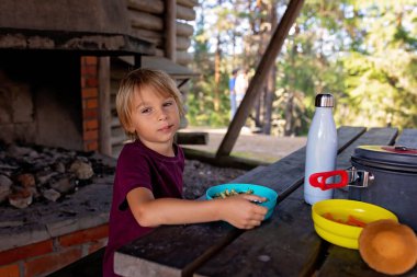 Mutlu çocuk, yol kenarındaki bir bankta yemek yiyor, Norveç 'te aile yemeği yiyor.