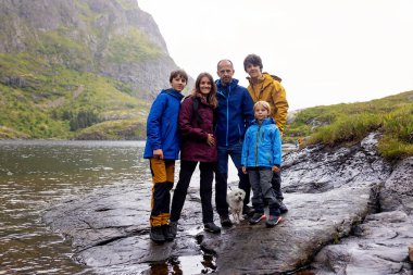 Kuzey Norveç, Lofoten 'in sonundaki küçük bir köyün manzarasının tadını çıkaran sevimli küçük bir çocuk.