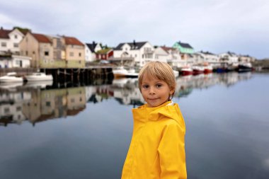 Child, boy, visiting Henningsvaer during the summer with family and pet dog clipart