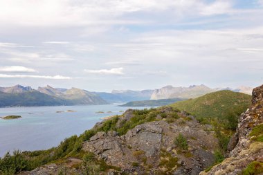 Family with children and pet, kids and adults hiking Sukkertoppen trail on Senja island, Norway clipart