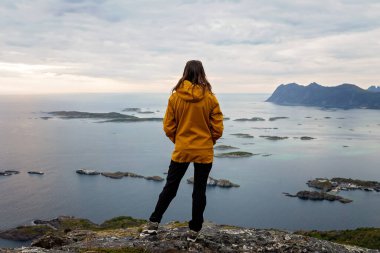 Çocuklu ve evcil hayvanlı aile, çocuklar ve yetişkinler Norveç 'in Senja adasında Sukkertoppen yolunda yürüyüş yapıyorlar.