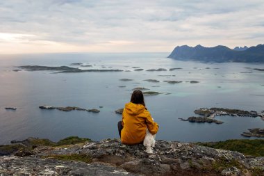 Çocuklu ve evcil hayvanlı aile, çocuklar ve yetişkinler Norveç 'in Senja adasında Sukkertoppen yolunda yürüyüş yapıyorlar.