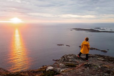 Çocuklu ve evcil hayvanlı aile, çocuklar ve yetişkinler Norveç 'in Senja adasında Sukkertoppen yolunda yürüyüş yapıyorlar.