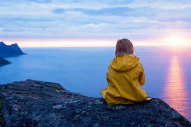 Çocuklu ve evcil hayvanlı aile, çocuklar ve yetişkinler Norveç 'in Senja adasında Sukkertoppen yolunda yürüyüş yapıyorlar.
