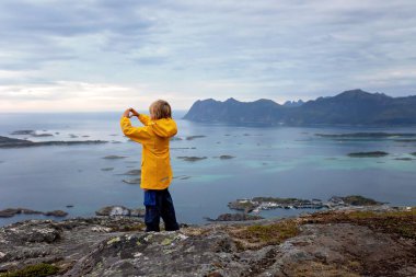 Çocuklu ve evcil hayvanlı aile, çocuklar ve yetişkinler Norveç 'in Senja adasında Sukkertoppen yolunda yürüyüş yapıyorlar.