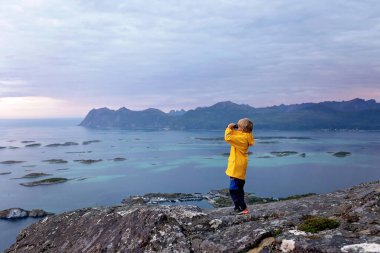 Family with children and pet, kids and adults hiking Sukkertoppen trail on Senja island, Norway clipart