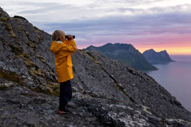 Çocuklu ve evcil hayvanlı aile, çocuklar ve yetişkinler Norveç 'in Senja adasında Sukkertoppen yolunda yürüyüş yapıyorlar.