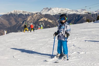 Çocuklar ve yetişkinler, kış giysileri içinde mutlu bir aile kayak tatilinde, kayak yaparken, kış tatilinde.