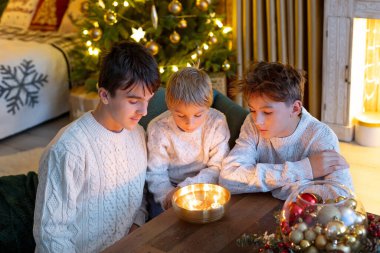 Tatlı çocuklar, sevimli çocuklar, kardeşler, Noel 'de Noel oyuncaklarıyla oynuyorlar, fındık kabuğunda mumlar yakıyorlar, czech Noel gelenekleri, ışıklandırmalı rahat bir yer.