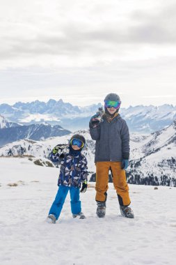 Çocuklar ve yetişkinler, kış giysileri içinde mutlu bir aile kayak tatilinde, kayak yaparken, kış tatilinde.