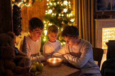 Tatlı çocuklar, sevimli çocuklar, kardeşler, Noel 'de Noel oyuncaklarıyla oynuyorlar, fındık kabuğunda mumlar yakıyorlar, czech Noel gelenekleri, ışıklandırmalı rahat bir yer.