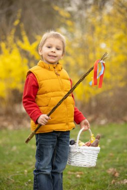 Cute preschool child, boy, holding handmade braided whip made from pussy willow, traditional symbol of Czech Easter used for whipping girls and women to receive eggs and sweets