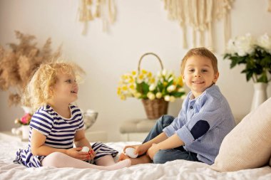 Happy children, siblings, enjoying Easter holiday together, tradition with handmade twig, braided whip made from pussy willow, traditional symbol of Czech Easter