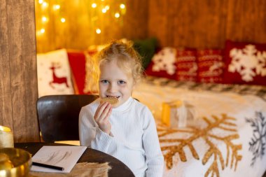 Mutlu şirin çocuk, Noel 'deki kız, güzel dekore edilmiş bir evde Noel tatilinin tadını çıkarıyor. 