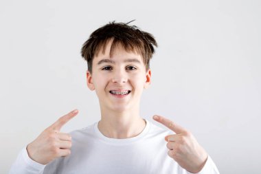 Ergen çocuk, çocuk, parantez takıyor, izole edilmiş, kapalı portre, diş fırçası kullanıyor.