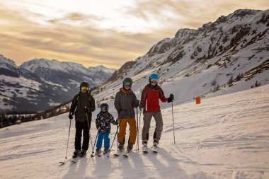 Çocuklar ve yetişkinler, kış giysileri içinde mutlu bir aile kayak tatilinde, kayak yaparken, kış tatilinde.