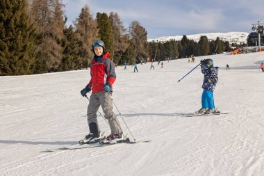 Çocuklar ve yetişkinler, kış giysileri içinde mutlu bir aile kayak tatilinde, kayak yaparken, kış tatilinde.