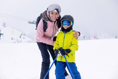 Çocuklu mutlu bir aile, kış kayak merkezinde okul çocukları, kış zamanı kayak.