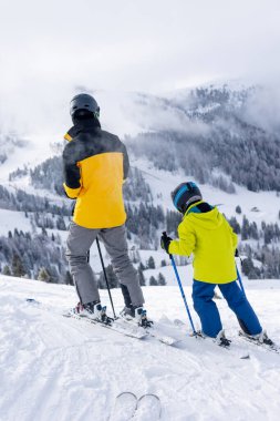 Çocuklu mutlu bir aile, kış kayak merkezinde okul çocukları, kış zamanı kayak.