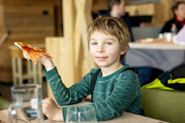 Çocuk, çocuk, İtalyan Alplerinde kayak yaparken restoranda pizza yemek, kışın tadını çıkarmak.