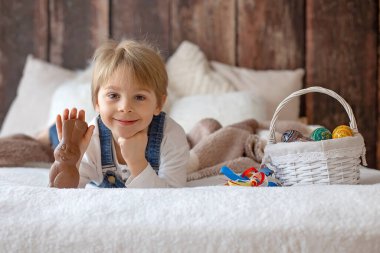 Stüdyodaki tatlı çocuk, Paskalya için yumurta ve çikolata yiyor, Paskalya tatilinde evde çocuk.