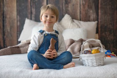 Stüdyodaki tatlı çocuk, Paskalya için yumurta ve çikolata yiyor, Paskalya tatilinde evde çocuk.
