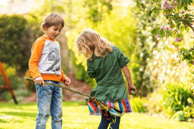 Happy children, siblings, enjoying Easter holiday together, tradition with handmade twig, braided whip made from pussy willow, traditional symbol of Czech Easter