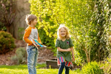 Happy children, siblings, enjoying Easter holiday together, tradition with handmade twig, braided whip made from pussy willow, traditional symbol of Czech Easter