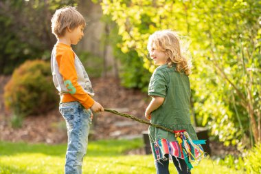 Happy children, siblings, enjoying Easter holiday together, tradition with handmade twig, braided whip made from pussy willow, traditional symbol of Czech Easter