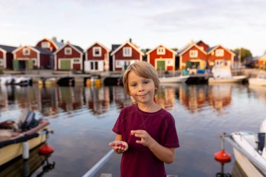 Aile, İsveç 'te küçük bir köy olan Lorudden' i ziyaret ediyor, yaz zamanı. İskandinav kıyı köyü