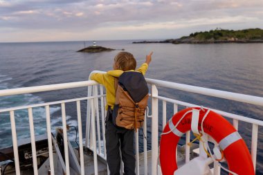 Millet, Bodo ve Lofoten Moskenesoya arasındaki feribot yolculuğunun tadını çıkarın. Yaz mevsimi, gün batımında çocuk ve yetişkinler feribotta.