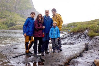 Kuzey Norveç, Lofoten 'in sonundaki küçük bir köyün manzarasının tadını çıkaran sevimli küçük bir çocuk.