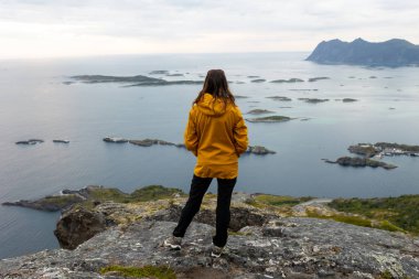 Çocuklu ve evcil hayvanlı aile, çocuklar ve yetişkinler Norveç 'in Senja adasında Sukkertoppen yolunda yürüyüş yapıyorlar.