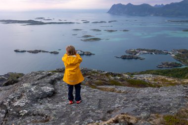 Çocuklu ve evcil hayvanlı aile, çocuklar ve yetişkinler Norveç 'in Senja adasında Sukkertoppen yolunda yürüyüş yapıyorlar.