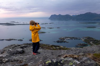 Çocuklu ve evcil hayvanlı aile, çocuklar ve yetişkinler Norveç 'in Senja adasında Sukkertoppen yolunda yürüyüş yapıyorlar.