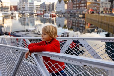 Tromso 'da güneşli bir günde Kuzey Norveç' in en büyük kuzey şehrini ziyaret eden sevimli anaokulu çocuğu.