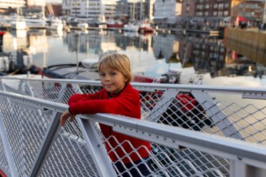 Tromso 'da güneşli bir günde Kuzey Norveç' in en büyük kuzey şehrini ziyaret eden sevimli anaokulu çocuğu.