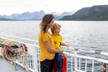 Çocuk, şirin çocuk, Norveç 'te bir feribottan dağlara bakıyor.