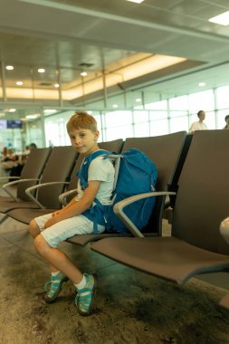 Mutlu çocuk, çocuk, ailesiyle seyahat ediyor, havaalanında uçağa binmek için bekliyor.