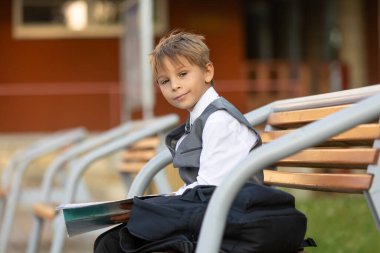 Sevimli birinci sınıf çocuğu, okula gidiyor. Birinci sınıf öğrencisi için okuldaki ilk gün, okula başlayan çocuk, öğretmene çiçek getiren, ilgilenen sırt çantası