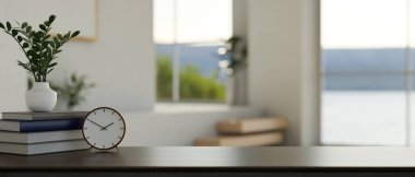 Kitapları, çalar saati, dekor bitkisi ve ürün sergisi için arka planda bulanık, parlak oturma odası olan modern siyah masa. 3d görüntüleme, 3d illüstrasyon