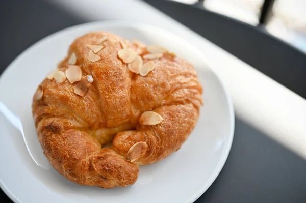 俯瞰图片 新鲜的法国杏仁羊角面包在白盘上 面包店 咖啡店 咖啡店 — 图库照片