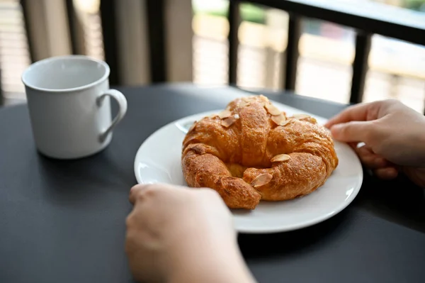 Mãos Femininas Segurando Delicioso Croissant Francês Fresco Com Fatia Amêndoa — Fotografia de Stock
