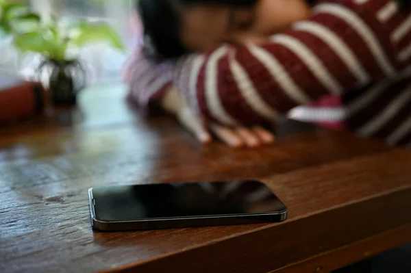 Smartphone Ett Träbord Över Suddig Bakgrund Trött Ung Asiatisk Kvinna — Stockfoto