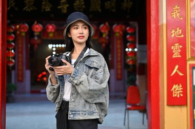 Genç ve güzel bir kadının portresi. Tatili sırasında Asya 'nın yerel Çin tapınağını gezerken manzaraya bakıyor. 