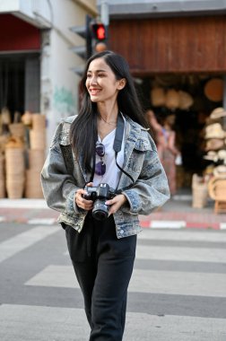 Genç ve güzel bir turistin portresi. Tatil sırasında markette karşıdan karşıya geçiyor. 