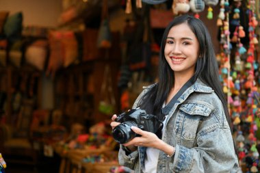 Genç ve güzel bir kadının resmi. Tatil sırasında markette dolaşırken kameraya gülümsüyor. 