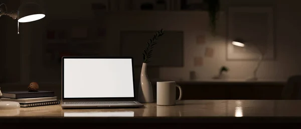ノートパソコンの白い画面のモックアップとテーブルの上のアクセサリーと夜のモダンな暗いオフィスワークスペースぼやけた暗いオフィスの背景 3Dレンダリング 3Dイラスト — ストック写真