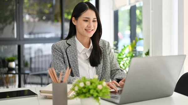 成功し プロの千年のアジアのビジネスマンや女性の上司は 彼女のオフィスで働いて ラップトップのキーボードを入力します — ストック写真