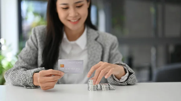 有魅力的亚洲女人手里拿着信用卡 桌上堆满了银币 Finance Banking Money Currency Investment — 图库照片